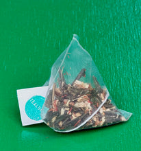 Load image into Gallery viewer, Tea bag with herbs on a green background

